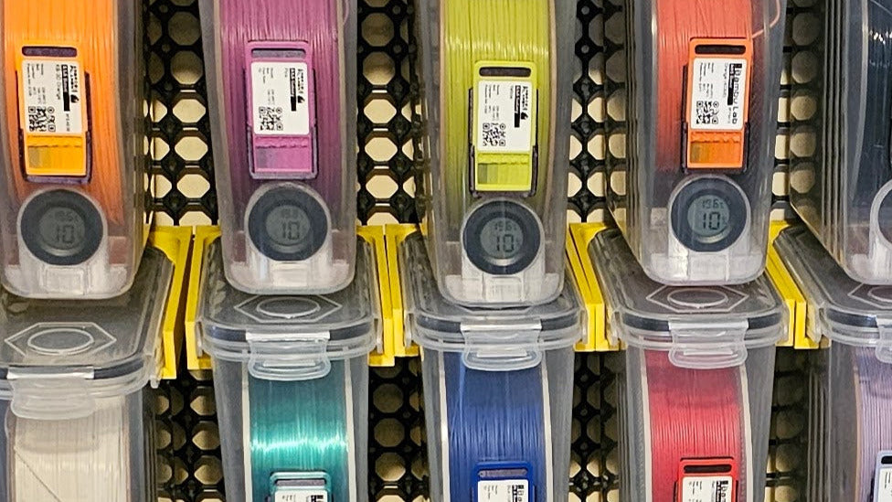 3D printing filament of various colors in storage bins